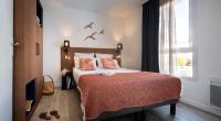 - une chambre avec un lit doté d&#39;une couverture rouge et d&#39;une fenêtre dans l&#39;établissement Pierre &amp; Vacances Premium Les Villas d&#39;Olonne, à Les Sables-dʼOlonne