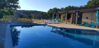 a swimming pool with chairs and a group at Village Bord de Ciel in Caylus