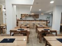 an empty restaurant with wooden tables and chairs at Village Bord de Ciel in Caylus