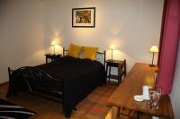 a bedroom with a black bed with yellow pillows and a table at Hôtel Les Charmilles de Mormal in Landrecies