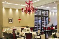 Un comedor con mesas y sillas y una lámpara de araña. en Kastens Hotel Luisenhof, en Hannover