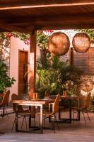 um pátio com mesas e cadeiras de madeira e luzes em Villa Praia - La Villa Group em Jericoacoara