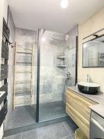 a bathroom with a sink and a glass shower at GRAND APPART TERRASSE PARKING DESIGN in Amiens