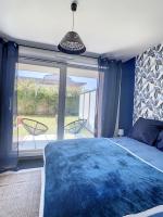 a bedroom with a blue bed and a large window at GRAND APPART TERRASSE PARKING DESIGN in Amiens