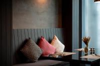 een groep kussens op een bank in een kamer bij Maitria Mode Sukhumvit 15 Bangkok - A Chatrium Collection in Bangkok