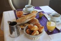 a table with a basket of bread and cups of orange juice at Logis Hotel Des Bains in Gérardmer