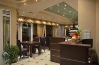 Un restaurante con mesas y sillas en una sala. en Garni Hotel Lion, en Jagodina