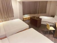 a hotel room with two beds and a table and a chair at Centre Hotel in Kaohsiung