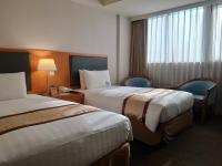 a hotel room with two beds and a window at Fuward Hotel Tainan in Tainan