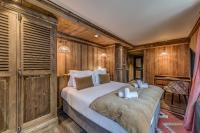 a bedroom with a bed in a room with wooden walls at HOTEL LE VAL D&#39;ISERE in Val-d&#39;Isère