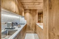 a kitchen with wooden walls and counters and a sink at HOTEL LE VAL D&#39;ISERE in Val-d&#39;Isère