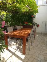 a wooden table and chairs on a patio at Adriana Nova Vas in Nova Vas