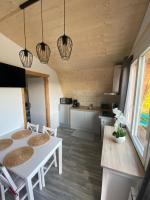 a kitchen and living room with a table and chairs at Au-Doux-Altic chalet romantique avec JACUZZI ET SAUNA in Métabief