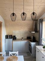 a kitchen with three lights hanging from the ceiling at Au-Doux-Altic chalet romantique avec JACUZZI ET SAUNA in Métabief