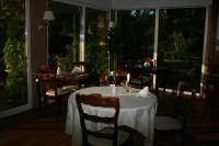 ein Esszimmer mit Tisch und Stühlen und Fenstern in der Unterkunft Logis Hotel du Lac in Neuvic