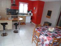 a kitchen with a table and a red wall at Les Gites De Colliers in Muides-sur-Loire