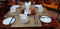 una mesa de madera con platos blancos y cubiertos en Sochati Casa Resort, en Nairobi