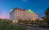 a building with two signs on top of it at Holiday Inn Foshan Nanhai Central by IHG in Foshan