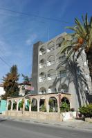 Un edificio alto con una palmera delante. en Le Village Hotel, en Limassol
