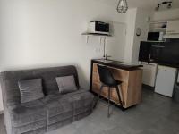 a living room with a couch and a microwave at Superbe appartement en rez-de-jardin à LANTON in Lanton