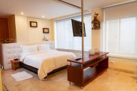 Un dormitorio con una cama y una mesa con televisión. en PlazaMar Pacifico Hotel, en Buenaventura
