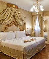 a bedroom with a large bed with two plates of food on it at Hotel Orsaria in Venice