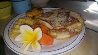 Un plato de comida con un sándwich y una flor. en Pondok Indah Bungalows Tetebatu, en Tetebatu