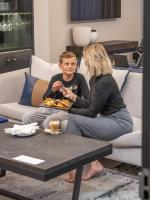 Una mujer sentada en un sofá con un joven comiendo comida. en Seven Villa Hotel & Spa, en Johannesburgo