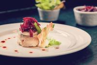 a white plate with a piece of food on a table at Hotel Tremoggia in Chiesa in Valmalenco