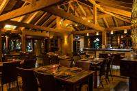 a restaurant with tables and chairs and a bar at Solar Mirador Exclusive Resort e SPA in Praia do Rosa