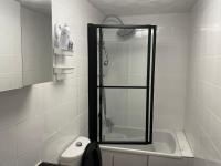 a bathroom with a shower and a toilet and a sink at Superbe appartement in Montataire