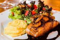 a plate of food with meat and potatoes and a salad at Solar Mirador Exclusive Resort e SPA in Praia do Rosa