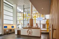 - un hall avec deux personnes assises à un bureau dans un bâtiment dans l&#39;établissement Hotel Campanile Paris-Bercy Village, à Paris