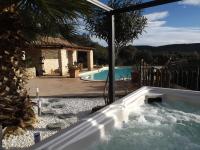 a swimming pool with a hot tub in a yard at Gite les bois 1 in Gignac