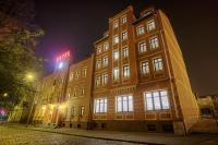 Un edificio con un cartel encima por la noche. en Hotel Kamieniczka, en Legnica