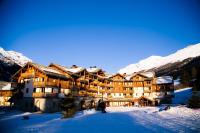 a large building in the snow with snow covered mountains at Les Alpages De Val Cenis by Resid&amp;co in Lanslebourg-Mont-Cenis