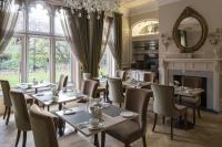 a dining room with tables and chairs and a fireplace at St Paul's Hotel in London
