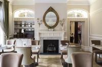 a dining room with a fireplace and tables and chairs at St Paul's Hotel in London
