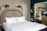 a bed with white pillows in a room at Grand Pigalle Hotel in Paris