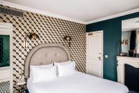 a bedroom with a white bed and a wall at Grand Pigalle Hotel in Paris