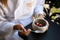 a woman holding a bowl of food with a spoon at Grand Pigalle Hotel in Paris