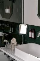 a bathroom with a white tub and a green tiled wall at Grand Pigalle Hotel in Paris