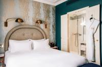 a bedroom with a white bed and a shower at Grand Pigalle Hotel in Paris