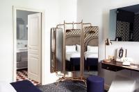 a hotel room with a mirror and a bed at Grand Pigalle Hotel in Paris