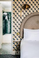 a bedroom with a bed and a checkerboard wall at Grand Pigalle Hotel in Paris