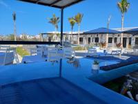 een zwembad met witte stoelen en palmbomen bij Las Palmas Hotel - Cerritos Beach in El Pescadero
