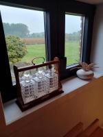 a window sill with four glass jars on it at Luxe-kamer Bed en Bokes 