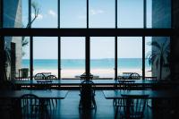un restaurante con mesas y sillas frente a una gran ventana en Colorit GOTO ISLANDS, en Goto