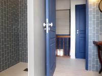 a hallway with blue doors and tile walls at Les 3 Graces, Cayeux-sur-mer, agréable maison in Cayeux-sur-Mer