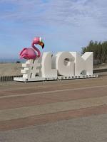 a large sign with a flamingo on top of it at Résidence arc en ciel, proche de la plage accés direct ,internet et parking privatif gratuit in La Grande Motte